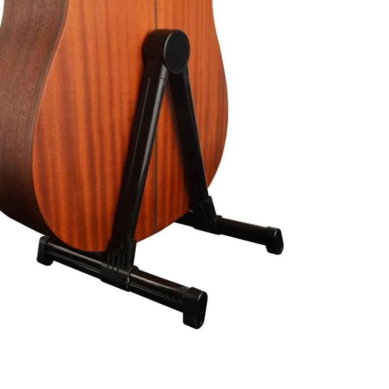 Acoustic guitar on a black stand against a white background